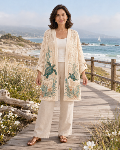 Woman wearing the Beige Seagrass Sea Turtle Summer Cardigan on a coastal boardwalk